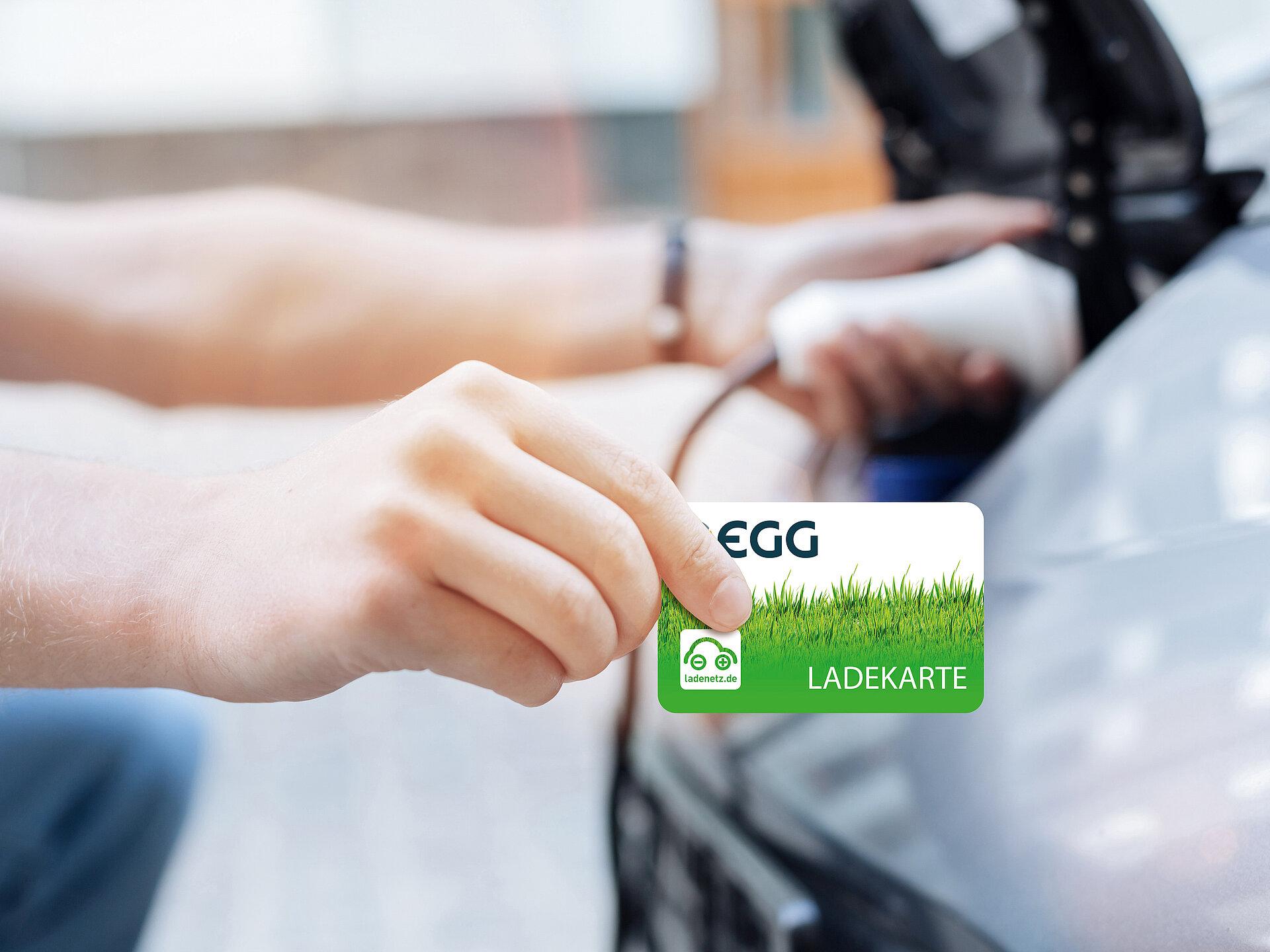 Ein Elektroauto wird geladen und dabei wir die Ladekarte zur Abrechnung gezeigt.
